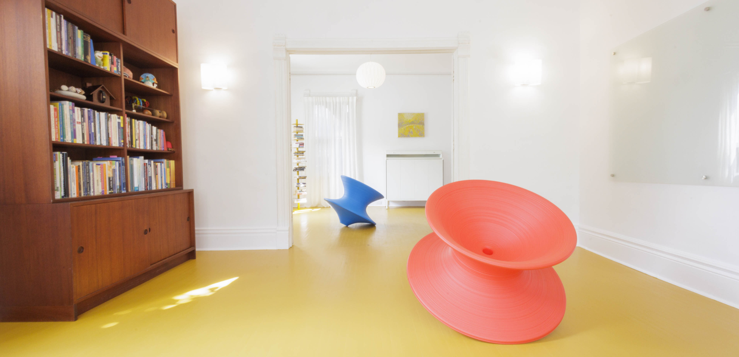 The Sensory Studio: inviting and curious red and blue spun chairs perched like oversized tops!